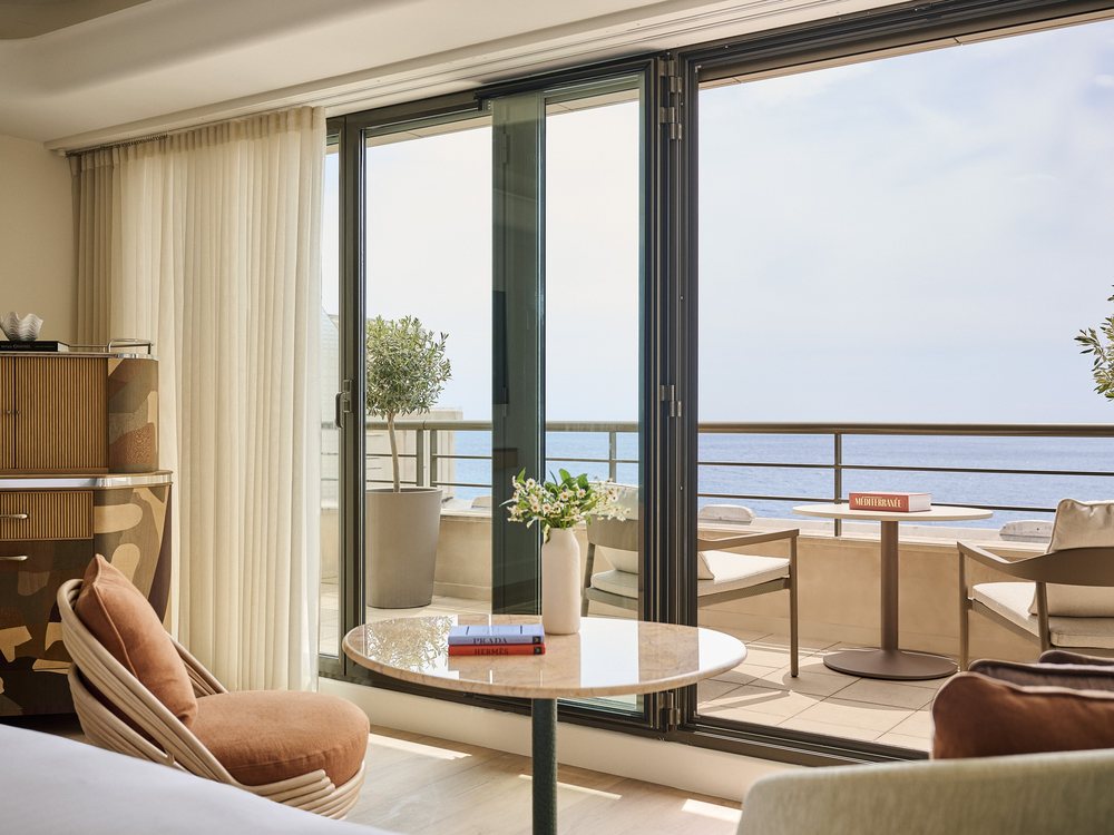 Une chambre Deluxe du Palais de la Méditerranée, sa baie vitrée et son balcon ouverts sur la mer