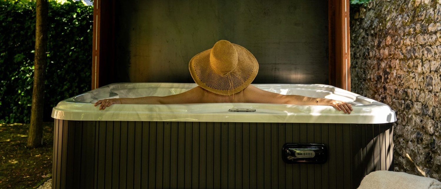 Le bain à remous du Spa du Verger, sous son abri d'acier corten, dans le jardin du Saint-Delis