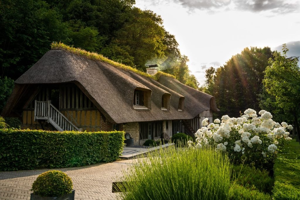 Bâtiment à colombages et toit de chaume de La Ferme Saint-Siméon, à Honfleur, au soleil couchant