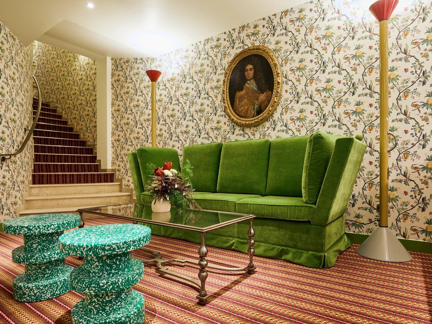 Un salon de l'Hôtel Prince de Conti, canapé de velours vert, papier peint fleuri et portrait ancien au mur