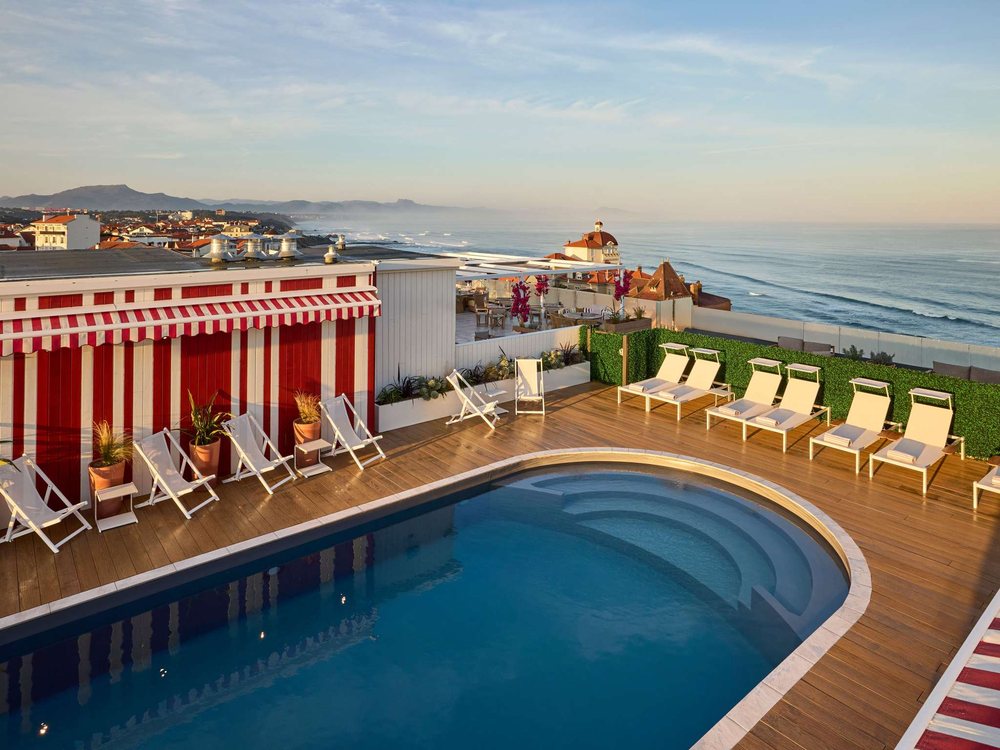 La piscine chauffée sur le toit du Talaia, à Biarritz, ses transats blancs, ses toiles rayées et l'océan à l'horizon