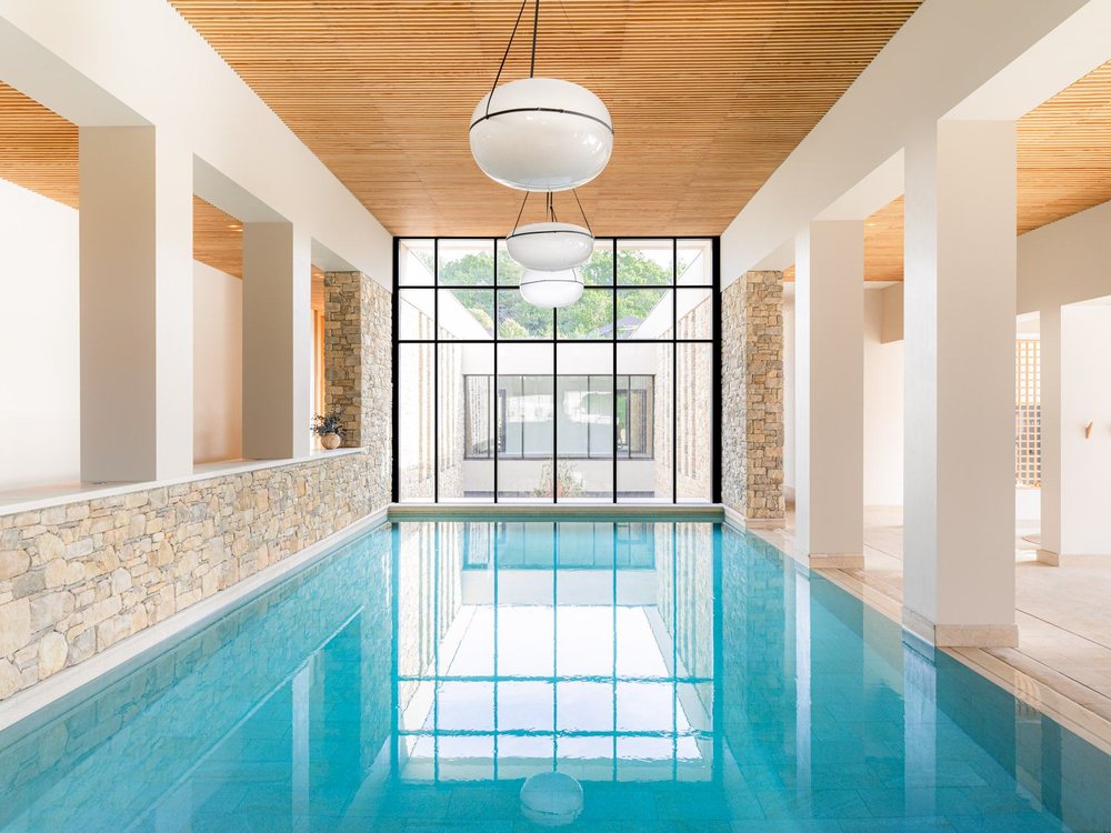 Le bassin de nage intérieur du spa L'Occitane du Couvent des Minimes, sous un plafond de bois