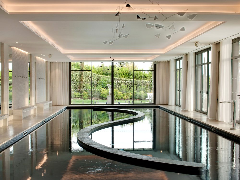 La piscine intérieure chauffée du spa du Domaine du Mas de Pierre, ouverte sur le jardin par de grandes baies