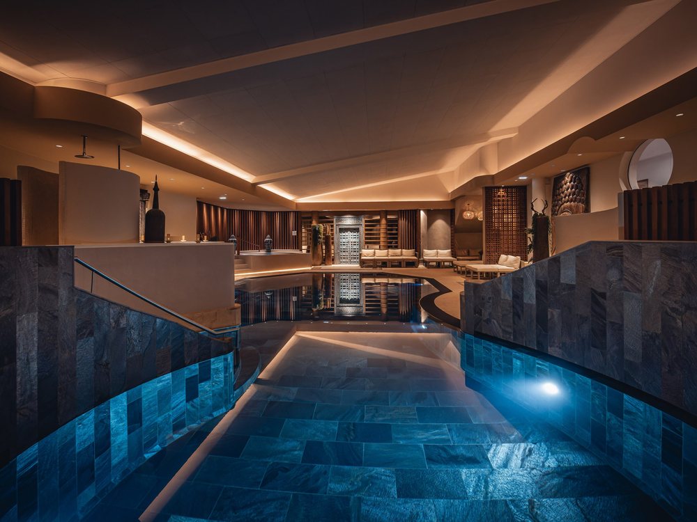 La piscine en pierre noire du spa Yonasaya de l'hôtel YONA, à Obernai, sous un plafond éclairé