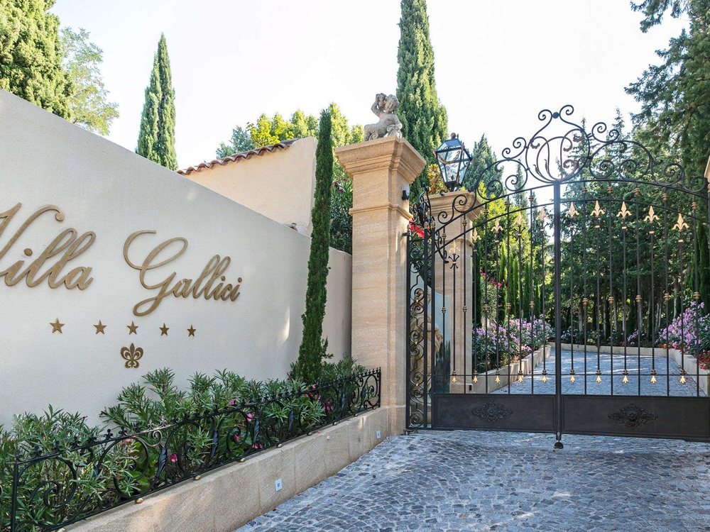 Le portail de la Villa Gallici, son nom gravé sur le mur, ses grilles ouvertes sur les cyprès et le jardin
