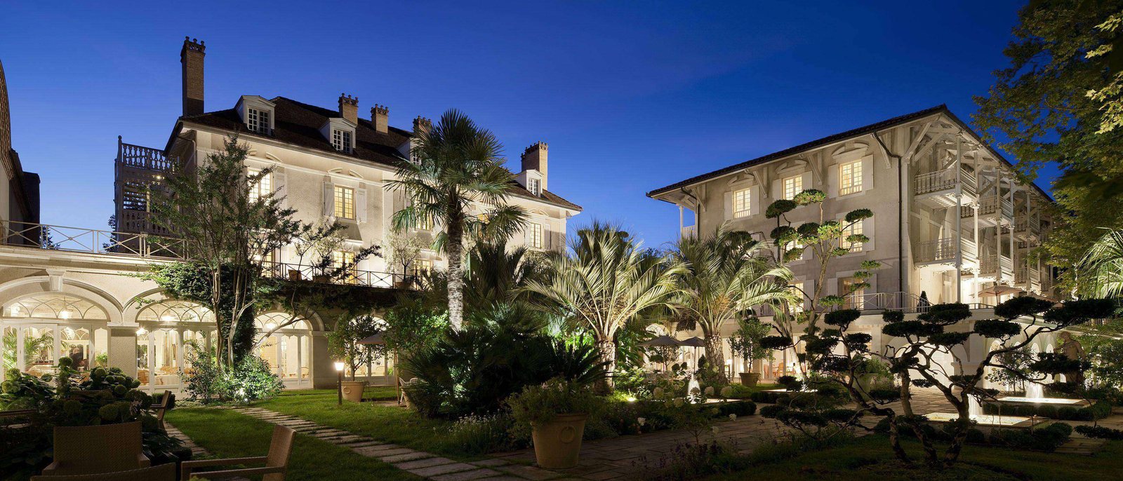Les Prés d'Eugénie à la tombée de la nuit, la maison blanche éclairée, ses palmiers et ses jardins, à Eugénie-les-Bains