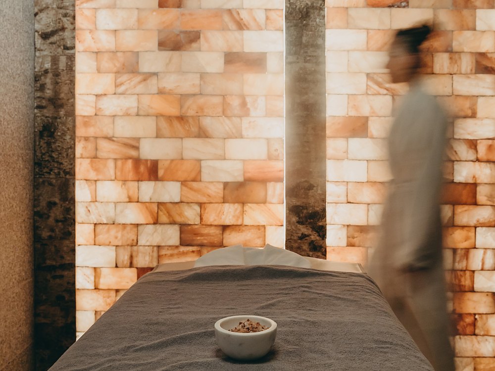 Une cabine du spa Pure Altitude des Fermes de Marie, contre un mur de sel rétroéclairé