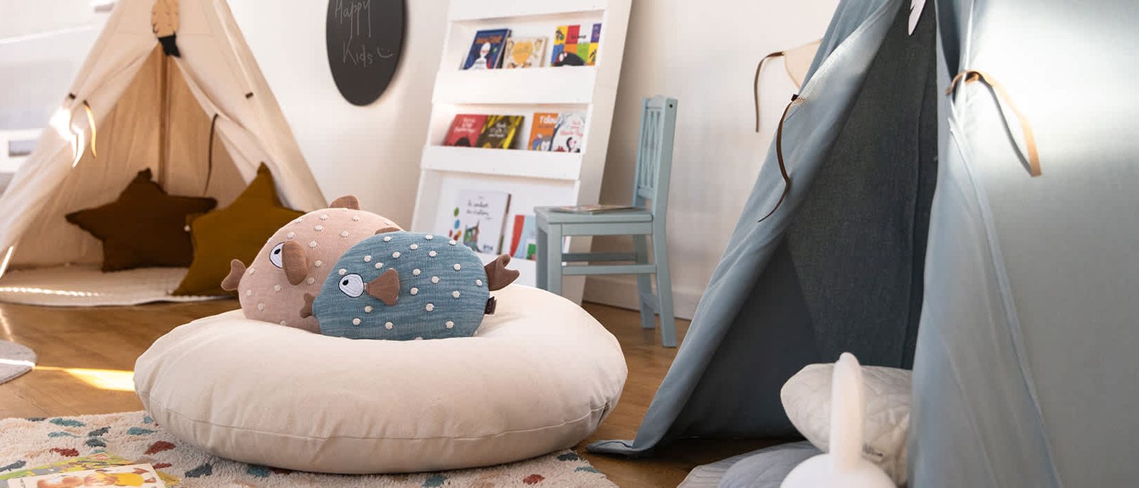 Un coin du Kid's Resort de l'Hôtel Royal, une tente en toile, des coussins et une bibliothèque d'enfant