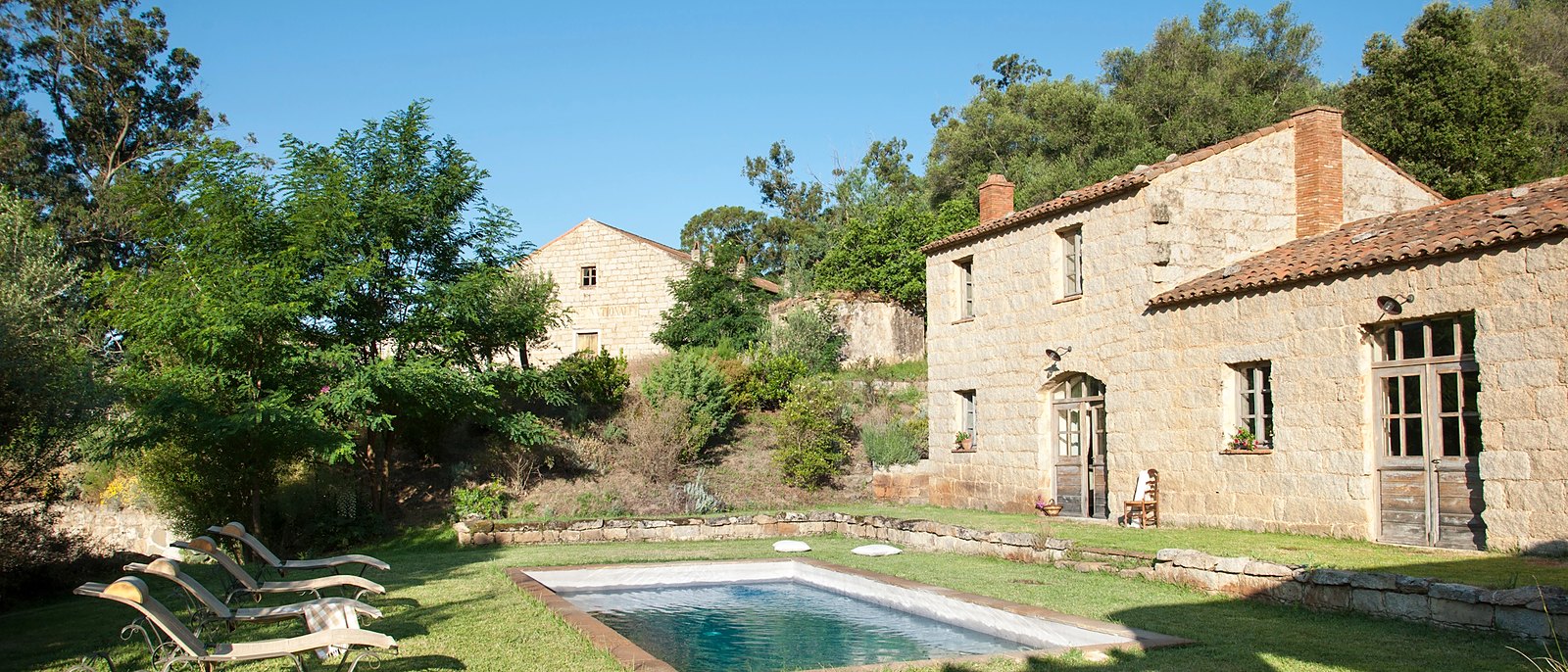 Une piscine du Hameau de Saparale devant une maison de pierre corse