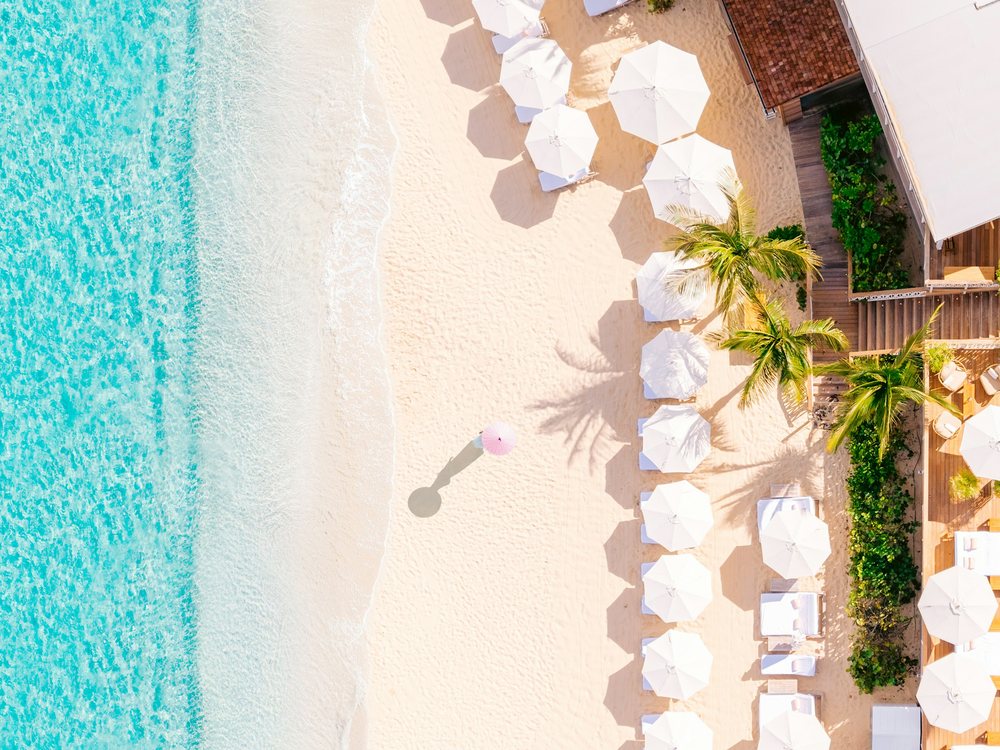 La plage des Flamands vue du ciel au Cheval Blanc St-Barth, ses parasols blancs le long de l'eau turquoise
