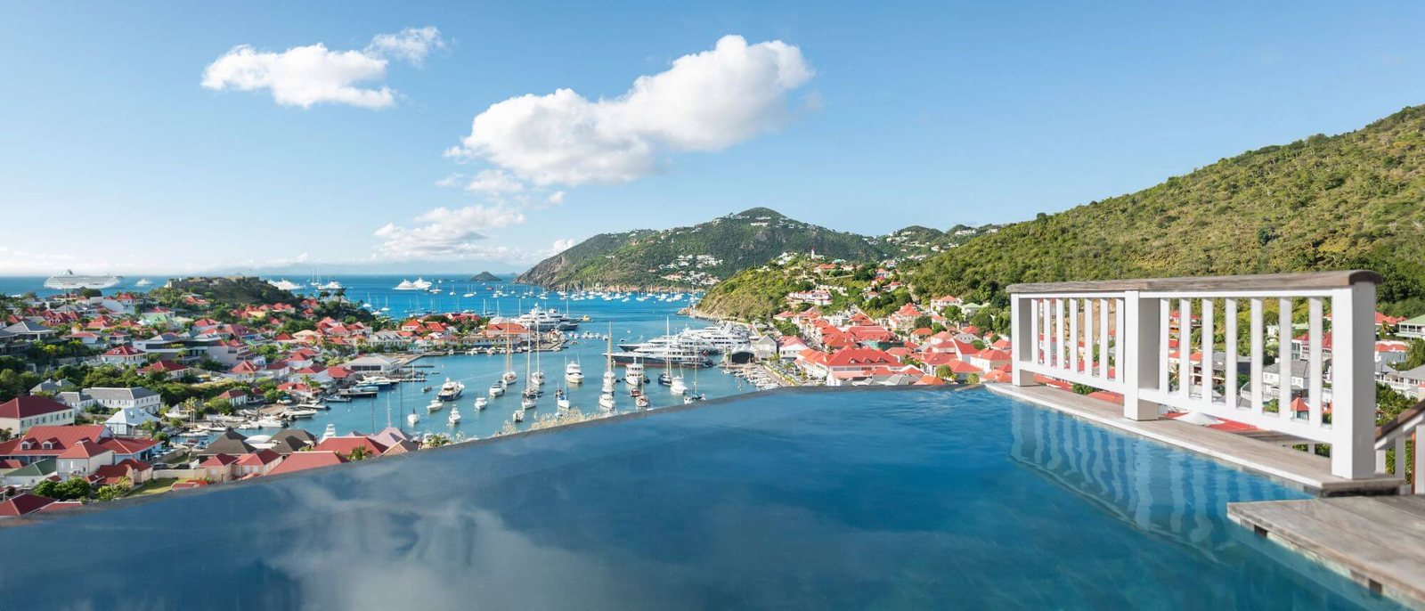 La piscine à débordement d'une suite du Fouquet's Saint-Barth, face au port de Gustavia et aux collines de l'île