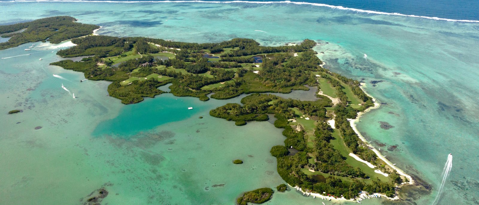 L'Île aux Cerfs vue du ciel, ses fairways entre la forêt et le lagon turquoise, au large de la côte est de l'île Maurice
