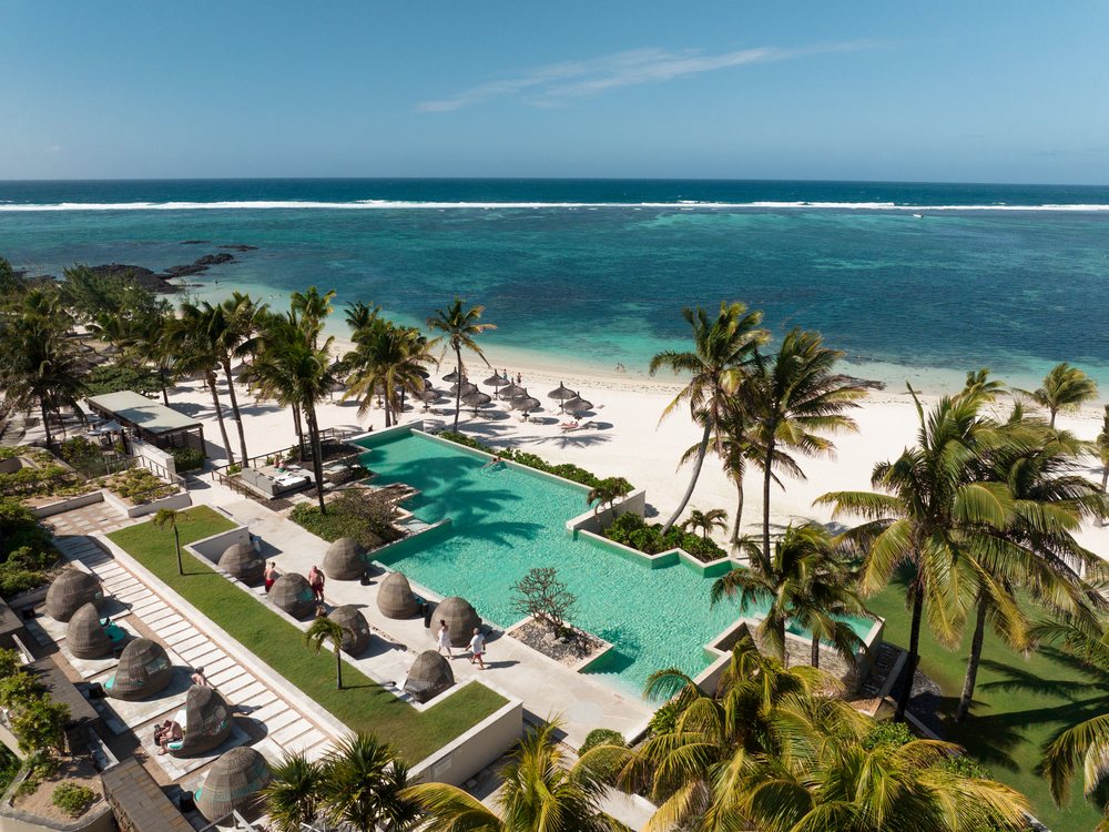 Vue aérienne de Long Beach Mauritius, sa piscine entre les palmiers et la plage de Belle Mare face au récif