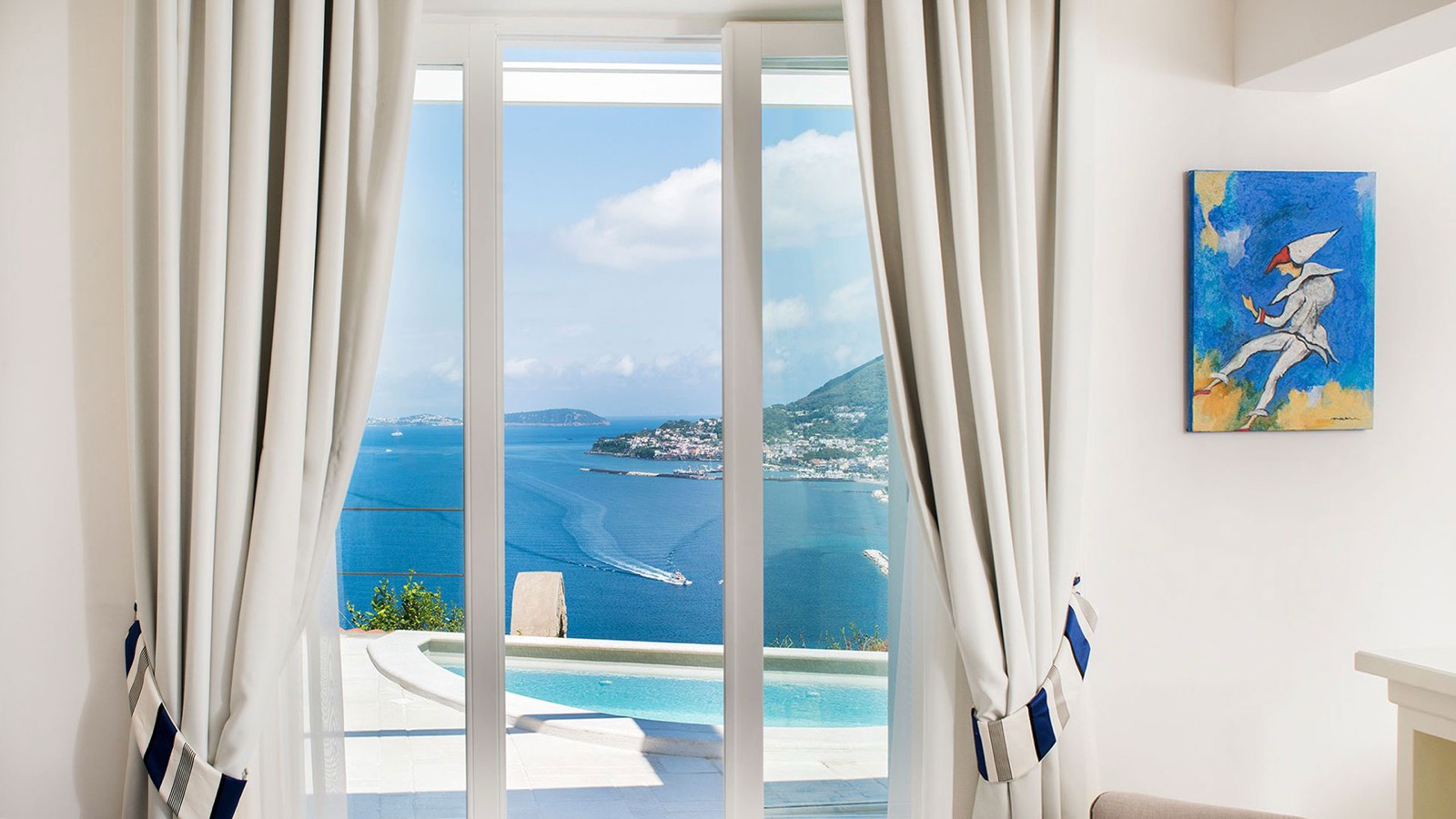 Depuis une suite du San Montano, porte-fenêtre ouverte sur une piscine privée et le golfe de Naples