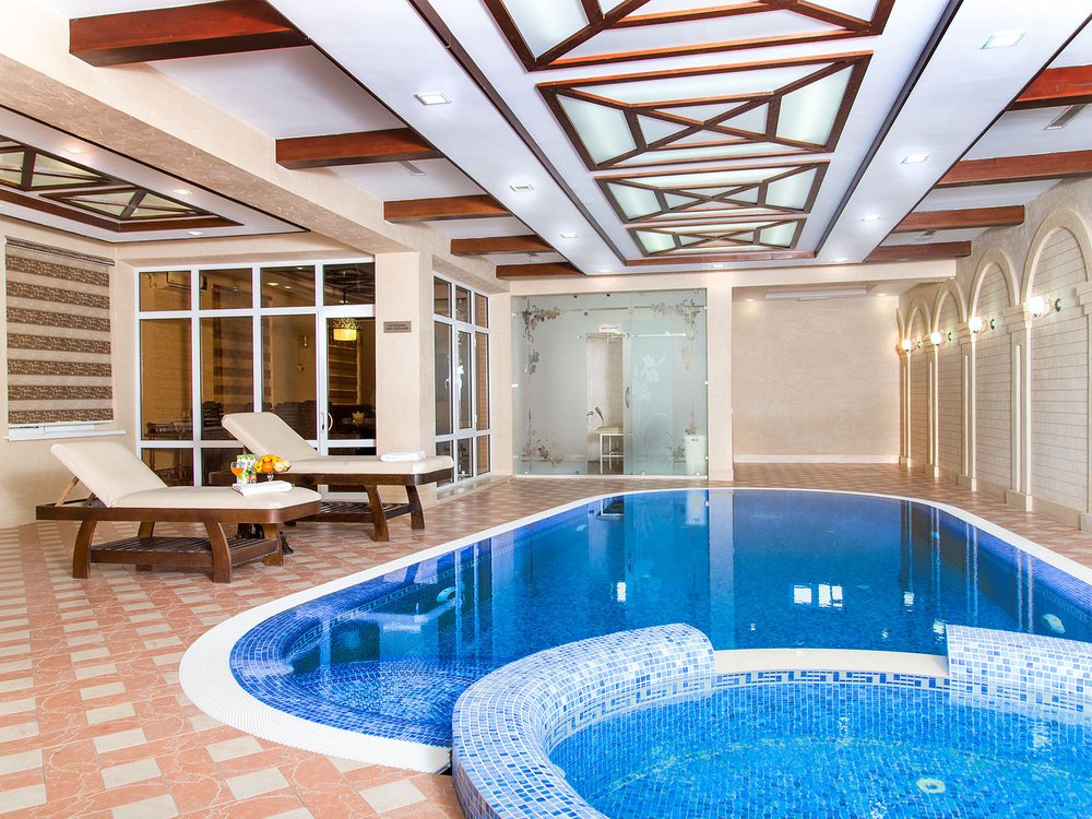 La piscine couverte chauffée du Marokand Spa Hotel et son bain à remous, sous un plafond de bois