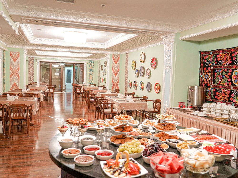 La salle du petit-déjeuner du Sangzor Boutique Hotel, ses assiettes peintes et sa tenture brodée