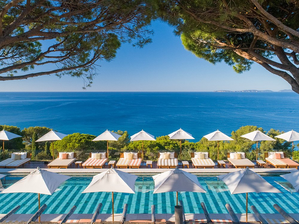 La piscine de Lily of the Valley et ses transats rayés, sous les pins face à la mer