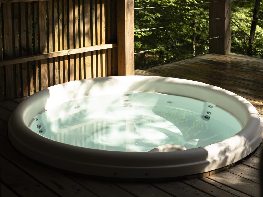Le jacuzzi privé d'un lodge de Loire Valley Lodges, sur une terrasse de bois ouverte sur la forêt