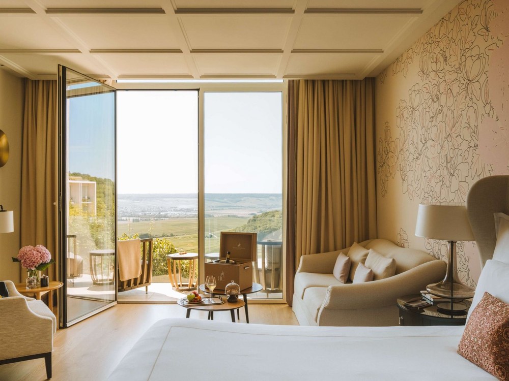 Une chambre du Royal Champagne, baie vitrée grande ouverte sur la terrasse et les vignes de Champagne