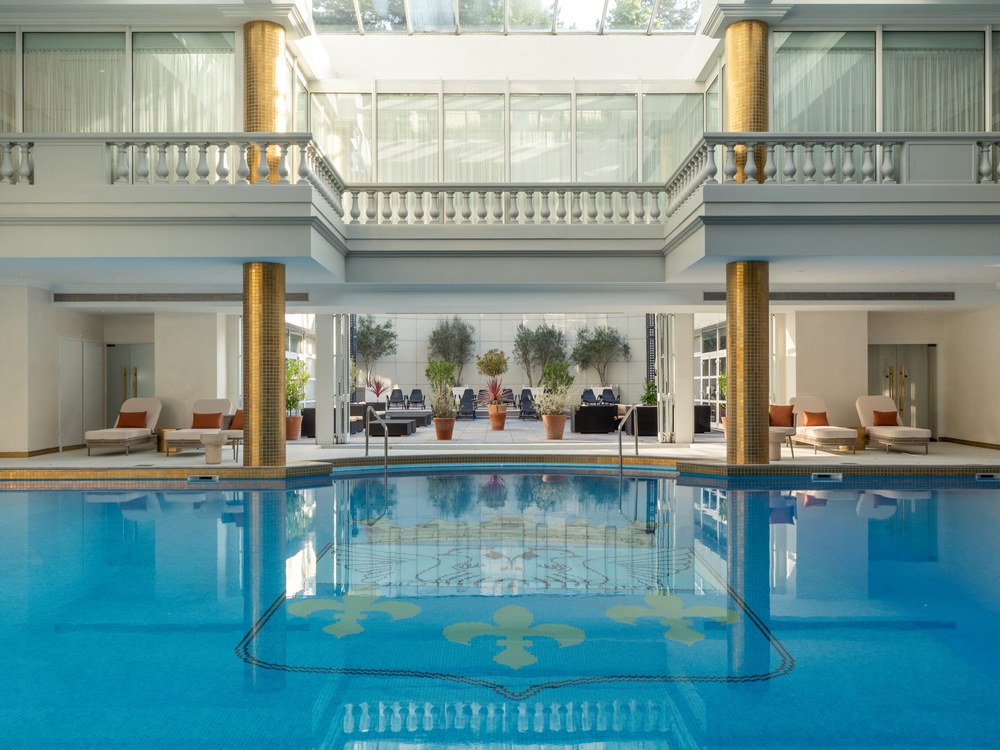 La piscine du Spa Guerlain au Trianon Palace, sous la verrière, entre colonnes dorées et balustres