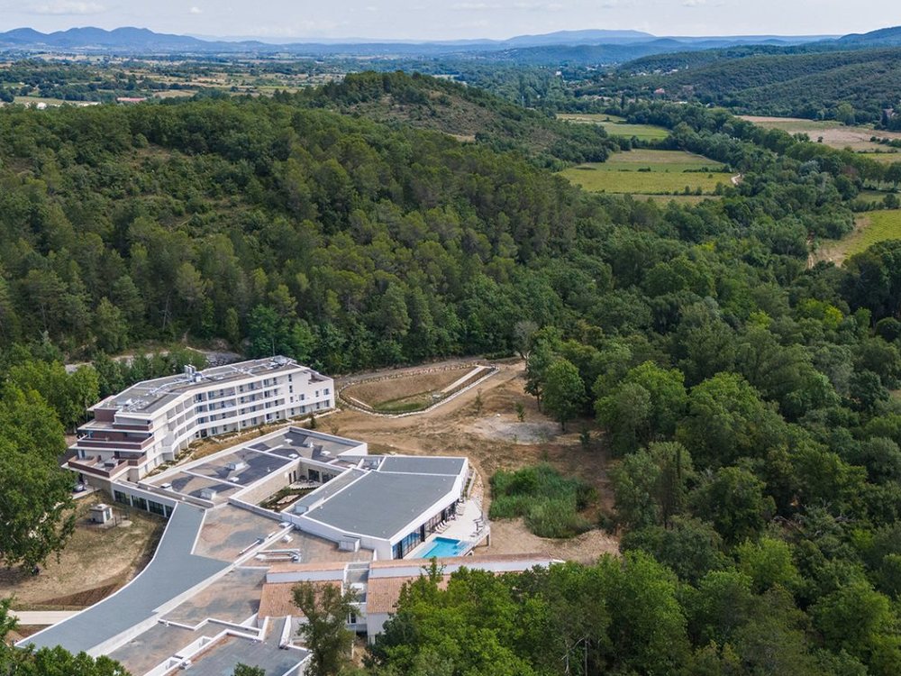 Vue aérienne du complexe thermal des Fumades et de l'Hôtel des Thermes, entre forêt et collines du Gard