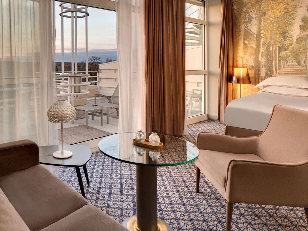 Une chambre du Célestins Spa Thermal & Hôtel, son salon et sa terrasse ouverte sur Vichy