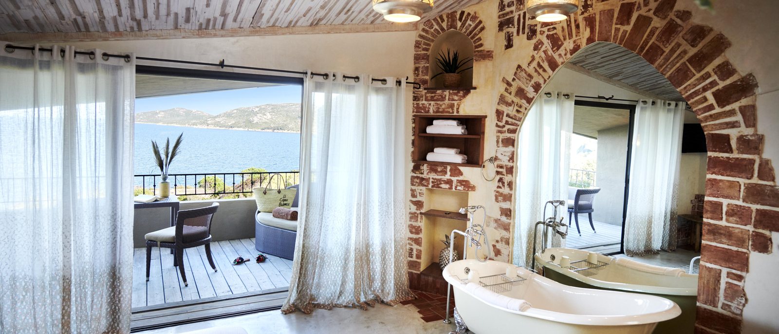 Une chambre vue mer d'U Capu Biancu, sa baignoire, son arche de pierre et son balcon sur la Méditerranée