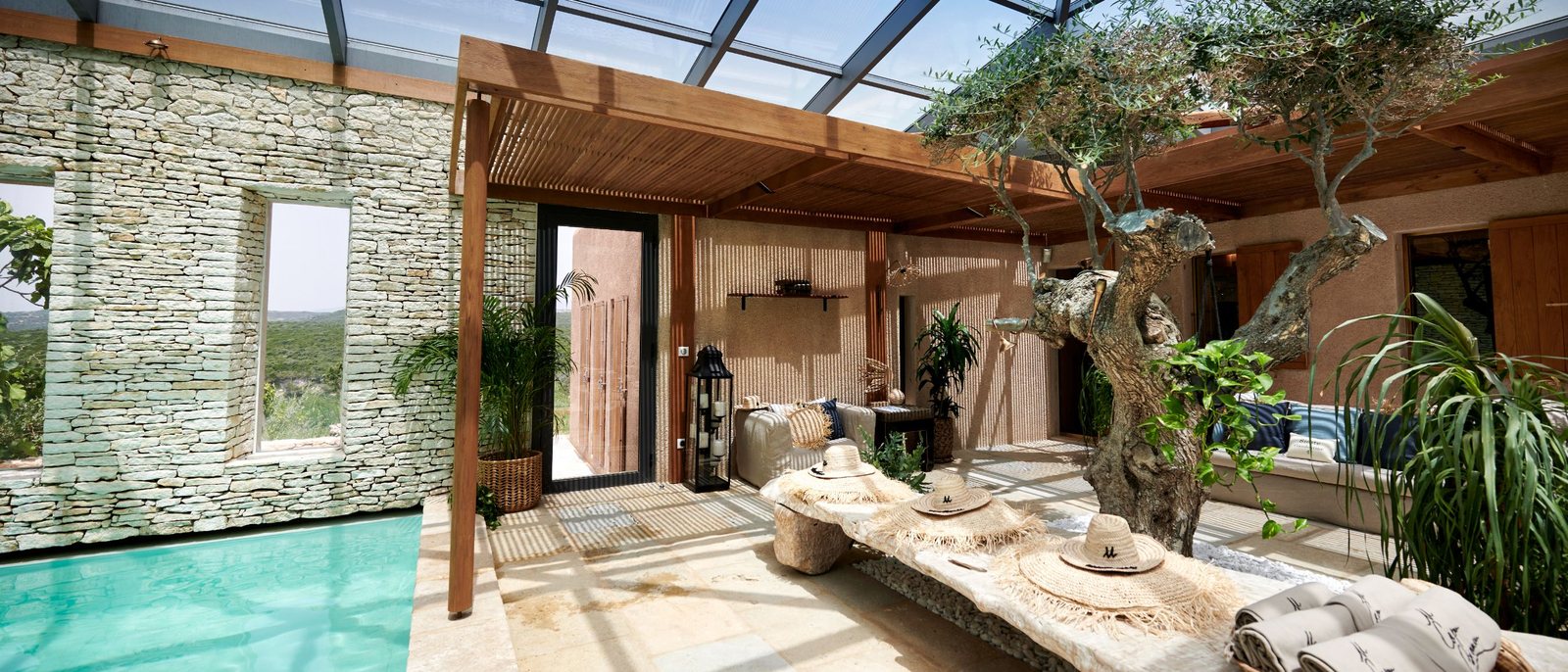 La piscine couverte de la Villa U Mulinu, à Bonifacio, sous sa verrière et contre son mur de pierre