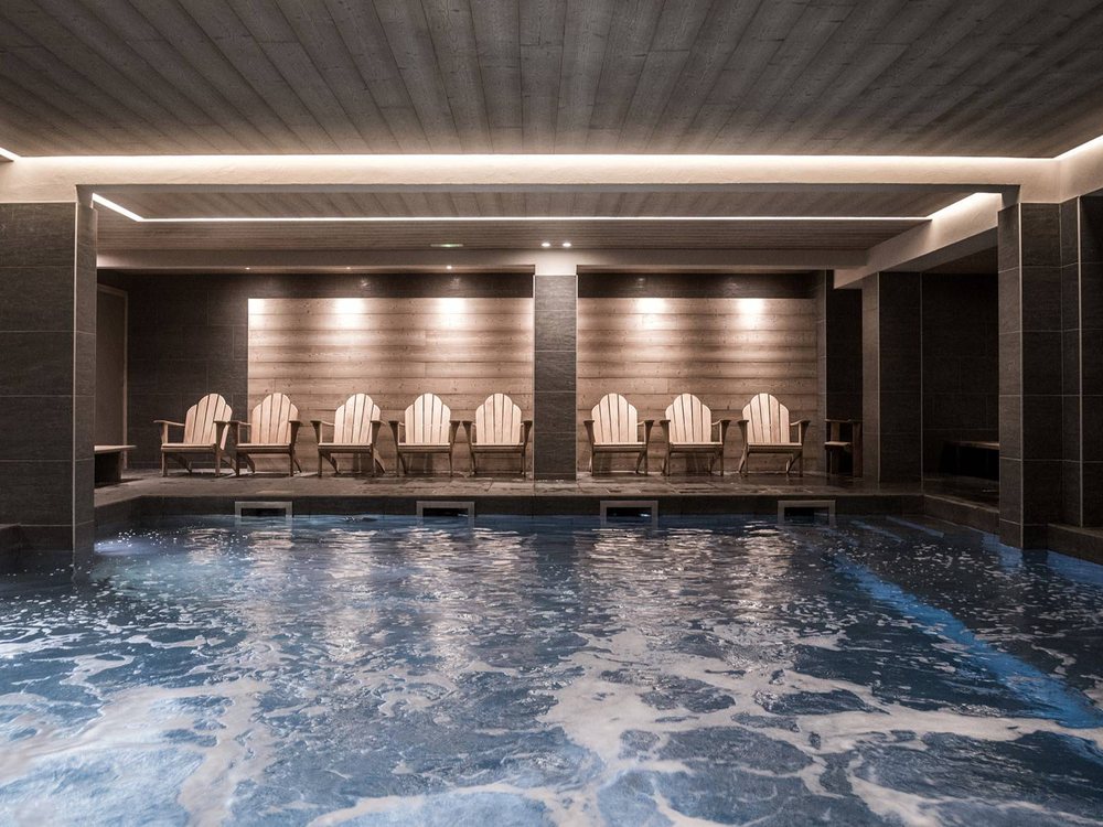 La piscine intérieure du Fitz Roy, son eau aux reflets argentés et sa rangée de fauteuils sous un éclairage doux