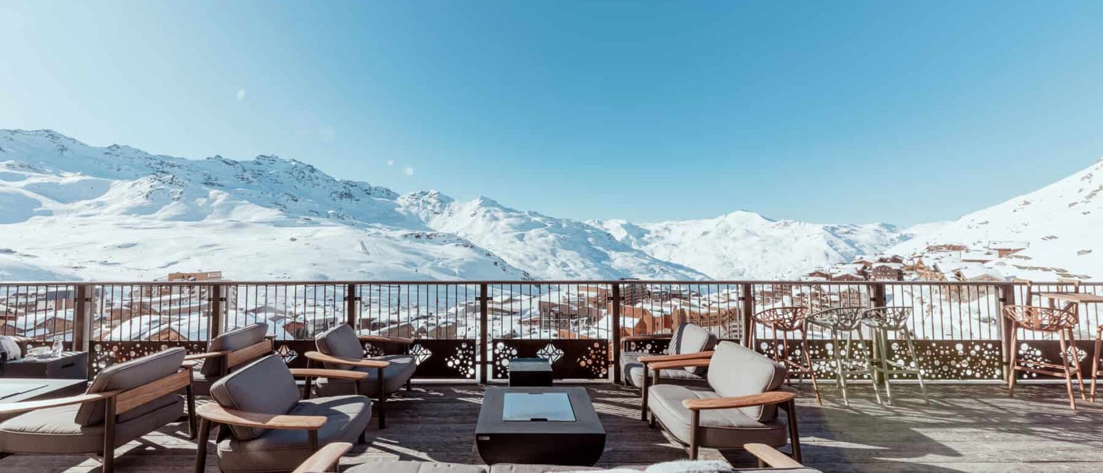 La terrasse du Koh-I Nor à Val Thorens, ses fauteuils et ses plaids face aux sommets enneigés des 3 Vallées, sous un ciel bleu