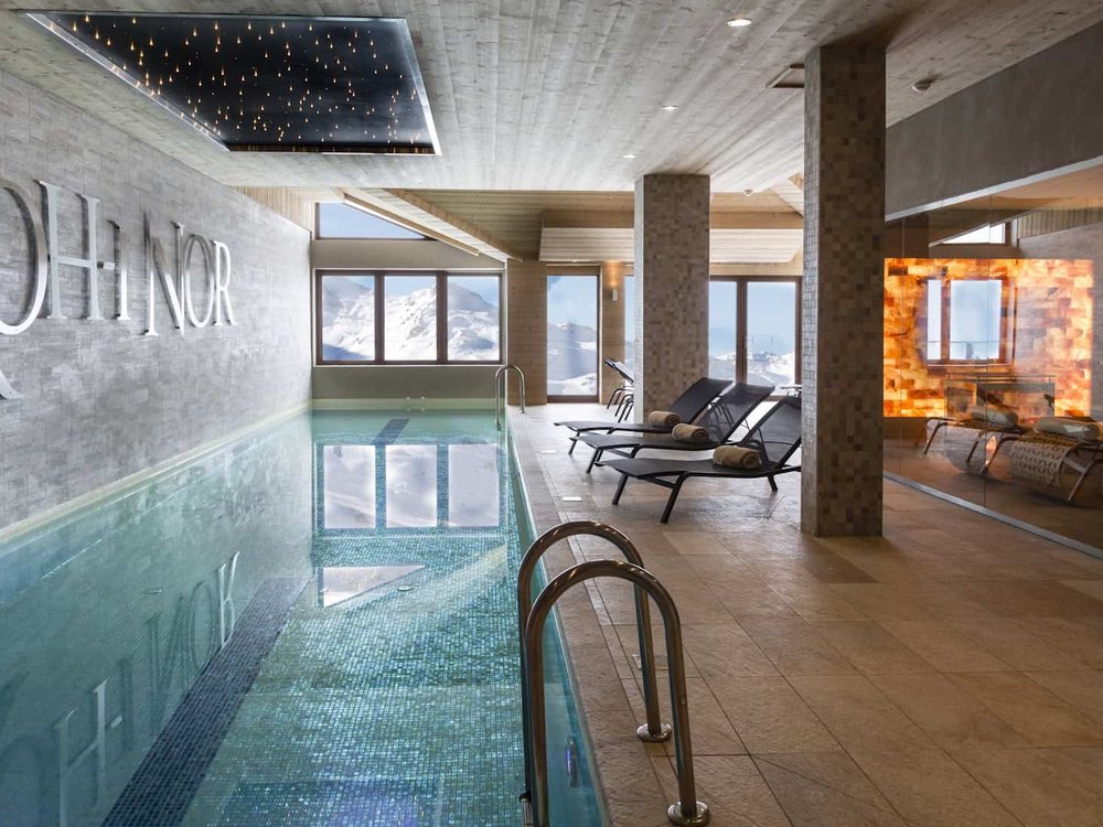 La piscine du spa Gemology du Koh-I Nor, ses transats, ses colonnes et le nom de l'hôtel sur le mur