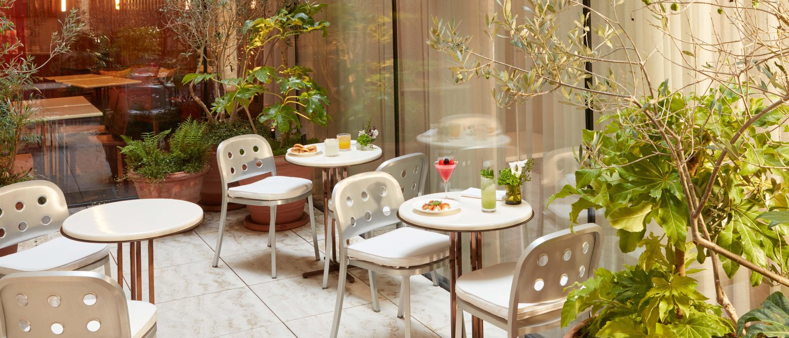 Le patio de la Villa des Prés, ses tables et sa végétation