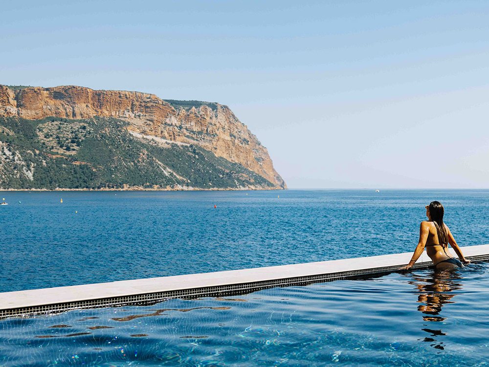 La piscine Infinity des Roches Blanches au ras de l'eau, face à la Méditerranée et au Cap Canaille