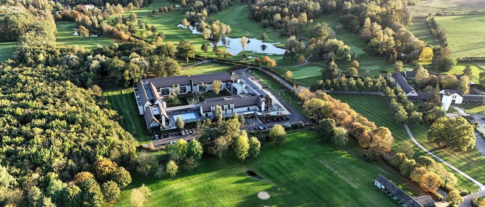 Le Domaine des Vanneaux vu du ciel, son bâtiment carré autour du patio, au milieu des fairways, des étangs et des bois du golf de L'Isle-Adam