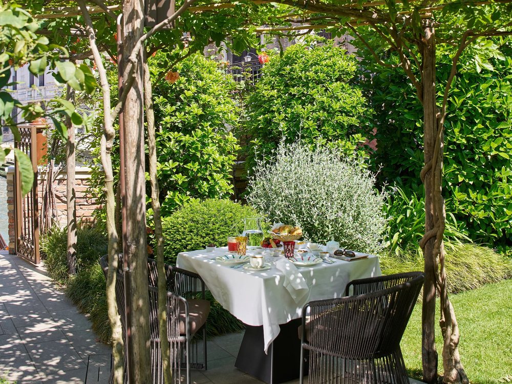 Une table du petit-déjeuner dressée dans le jardin de Madama Garden Retreat, sous la treille et les arbres