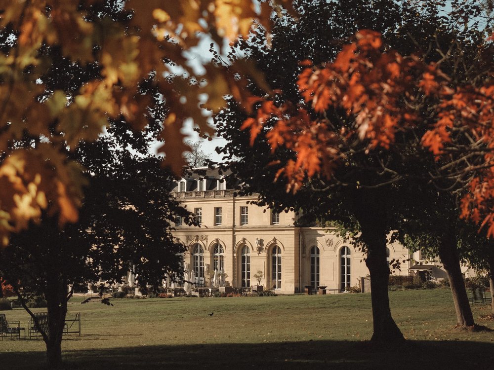 La Maison du Val, ancien pavillon de chasse de Louis XIV, entre les arbres d'automne de son parc